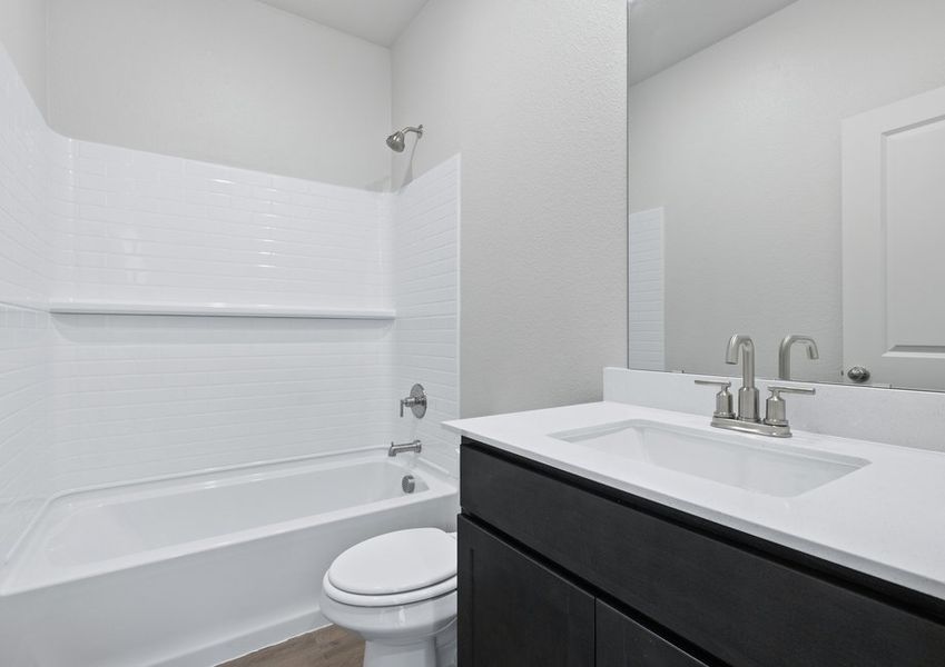 The secondary bathroom has a sprawling vanity and shower-tub combo.