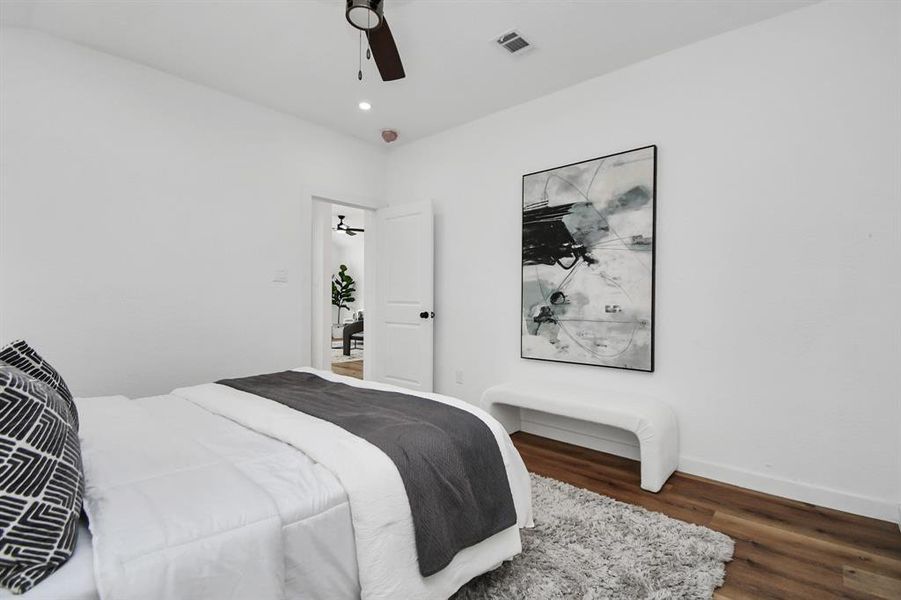 Modern bathroom featuring a double vanity with dark cabinetry and gold fixtures, twin mirrors, a walk-in shower with black tile detailing, and a separate toilet area. The space is bright and appears newly renovated.