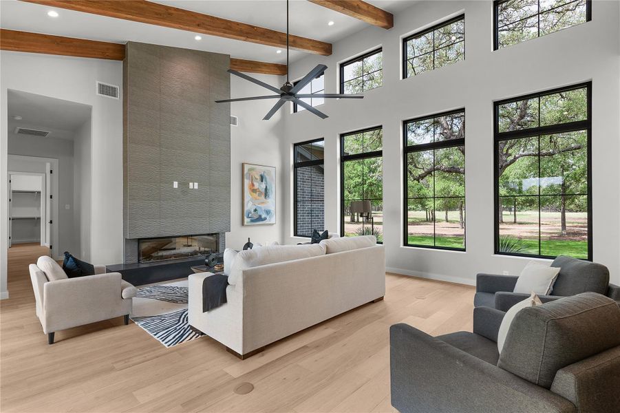 Living area with a towering ceiling, light wood-style floors, beam ceiling, recessed lighting, and ceiling fan Living area with a towering ceiling, light wood-style floors, beam ceiling, recessed lighting, and ceiling fan