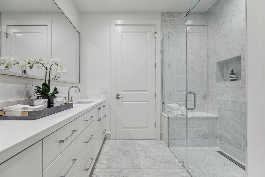 Alternate view of the primary bathroom highlighting the walk-in shower. Photos are of a similar unit with the same floor plan