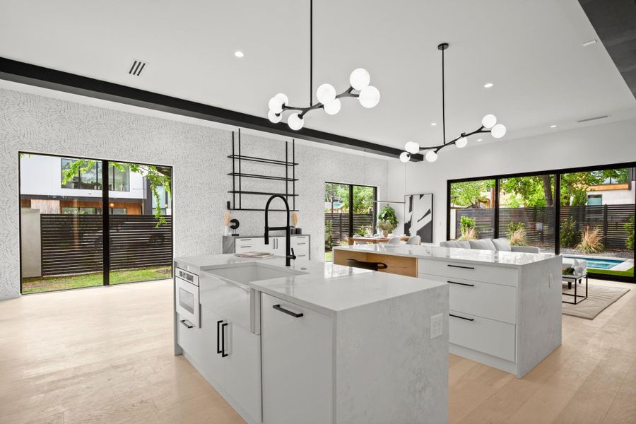 Kitchen with light stone counters, modern cabinets, and white cabinets