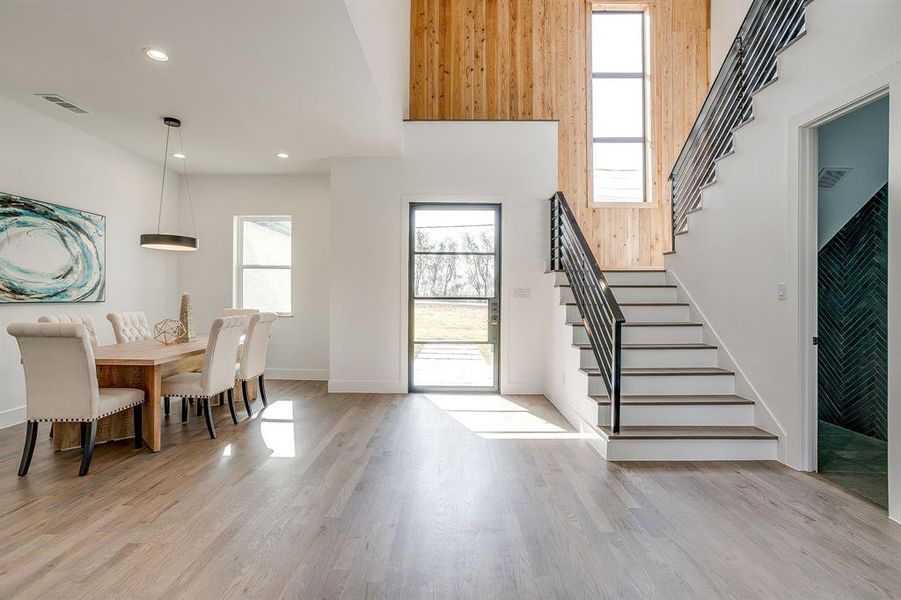 Entryway featuring plenty of natural light, stairs, light wood-type flooring, recessed lighting, and a towering ceiling Entryway featuring plenty of natural light, stairs, light wood-type flooring, recessed lighting, and a towering ceiling