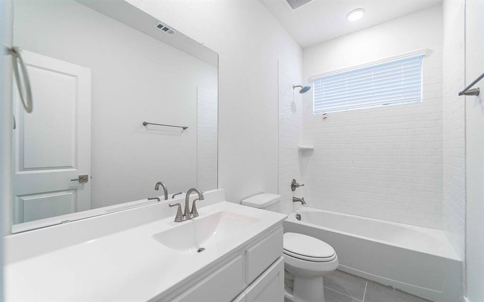 Bright bathroom featuring a single vanity with integrated sink, brushed nickel faucet, and full-width mirror