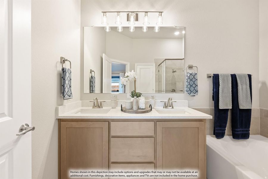 Bathroom with double-sink vanity, light wood cabinets, large mirror, and soaking tub beside a glass shower. Bathroom with double-sink vanity, light wood cabinets, large mirror, and soaking tub beside a glass shower.