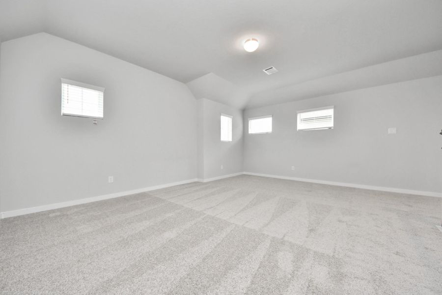 Discover a haven of leisure in this fantastic game room! Whether you're seeking a casual hangout or an adult gaming retreat, this space has it all. Enjoy the luxurious feel of plush carpet underfoot, the expansive ambiance of high ceilings, custom paint that adds a touch of personality, and windows that flood the room with refreshing natural light. Sample photo of completed home with similar floor plan. Actual colors and selections may vary.