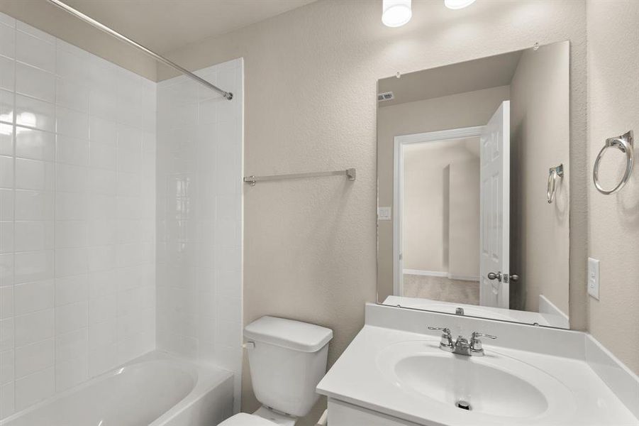 The secondary bath features tile flooring, white cabinetry and light countertops and a shower/tub combo. Perfect for accommodating any visiting family and friends.