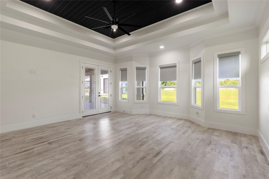 Another angle in the Primary bedroom showcases the designer tray ceiling with shiplap and the large ceiling fan to keep you comfortable. Designer remote-controlled window coverings are a bonus. The French doors lead you to the covered patio where you can enjoy a quiet evening listening to the birds. Another angle in the Primary bedroom showcases the designer tray ceiling with shiplap and the large ceiling fan to keep you comfortable. Designer remote-controlled window coverings are a bonus. The French doors lead you to the covered patio where you can enjoy a quiet evening listening to the birds.