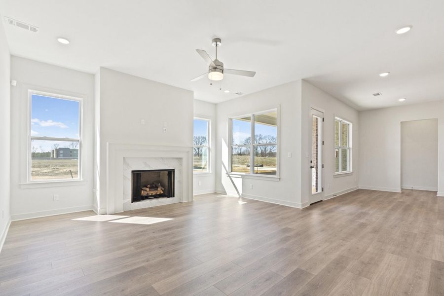 Unfurnished living room with a ceiling fan, a fireplace, light wood-type flooring, and recessed lighting