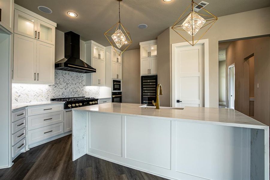 Kitchen with sink, white cabinetry, dark wood-type flooring, and wall chimney exhaust hood