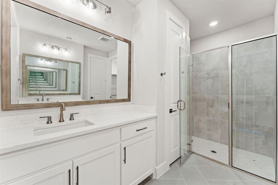 Bathroom with tile patterned floors, vanity, and a shower with shower door