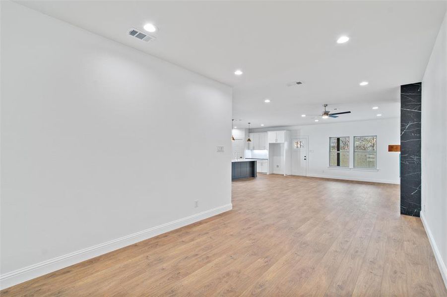 Unfurnished living room featuring light hardwood / wood-style flooring and ceiling fan