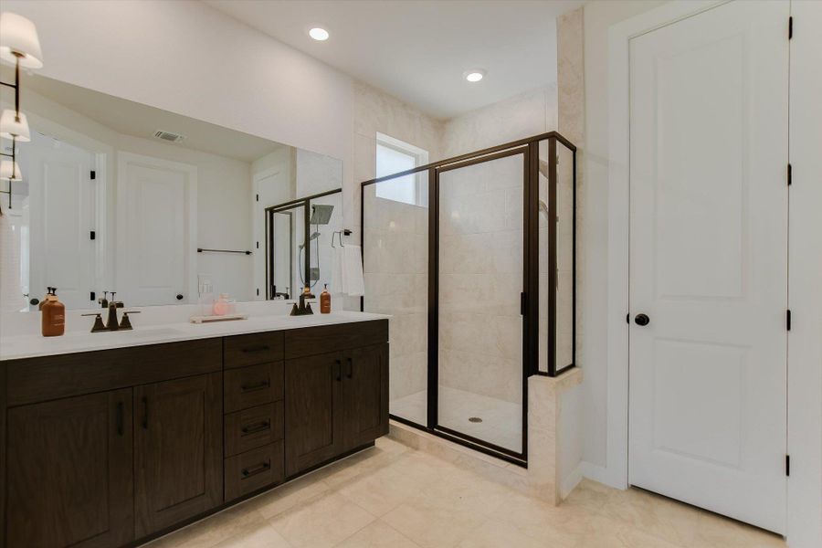 Dual vanities and a tiled walk-in shower elevate this well-appointed bathroom's appeal. Dual vanities and a tiled walk-in shower elevate this well-appointed bathroom's appeal.