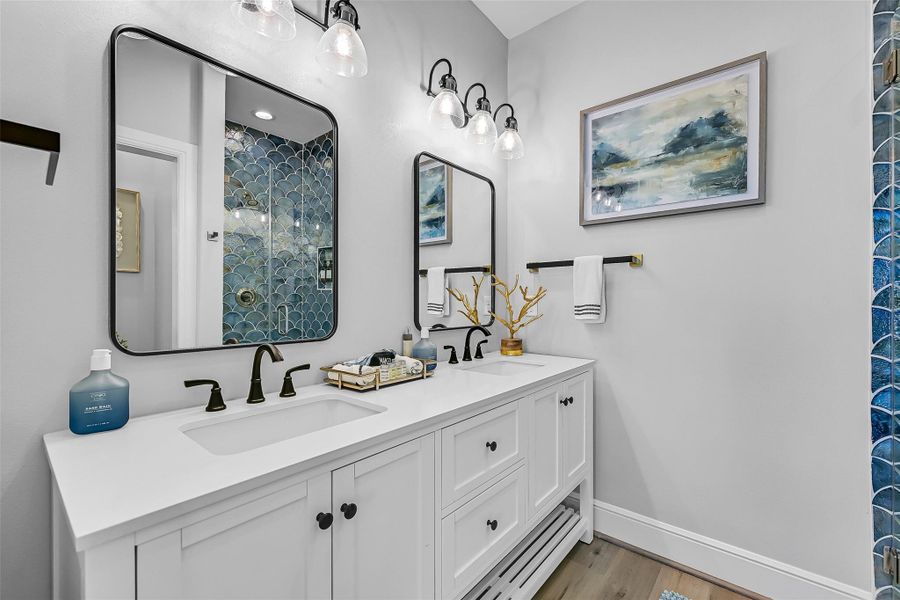 The second primary bath ensuite was designed with comfort in mind featuring double sinks, storage, beautiful detailed shower, and a layout that keeps busy mornings feeling effortless.