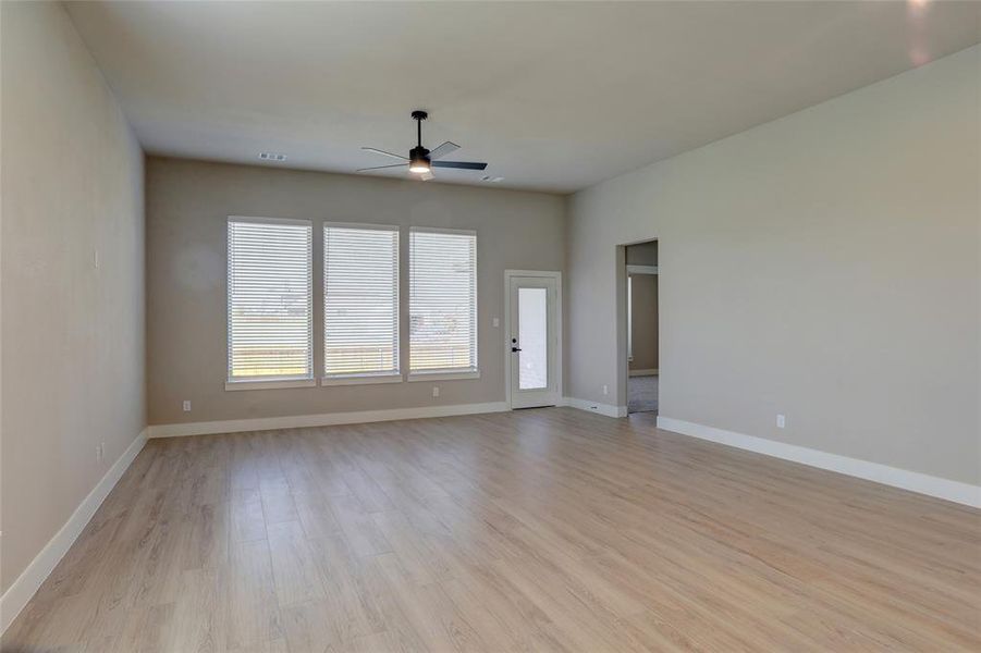 Empty room with light wood finished floors and a ceiling fan Empty room with light wood finished floors and a ceiling fan