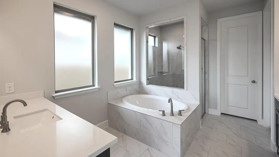 Full bathroom with a garden tub, vanity, a marble finish shower, and light marble finish floors