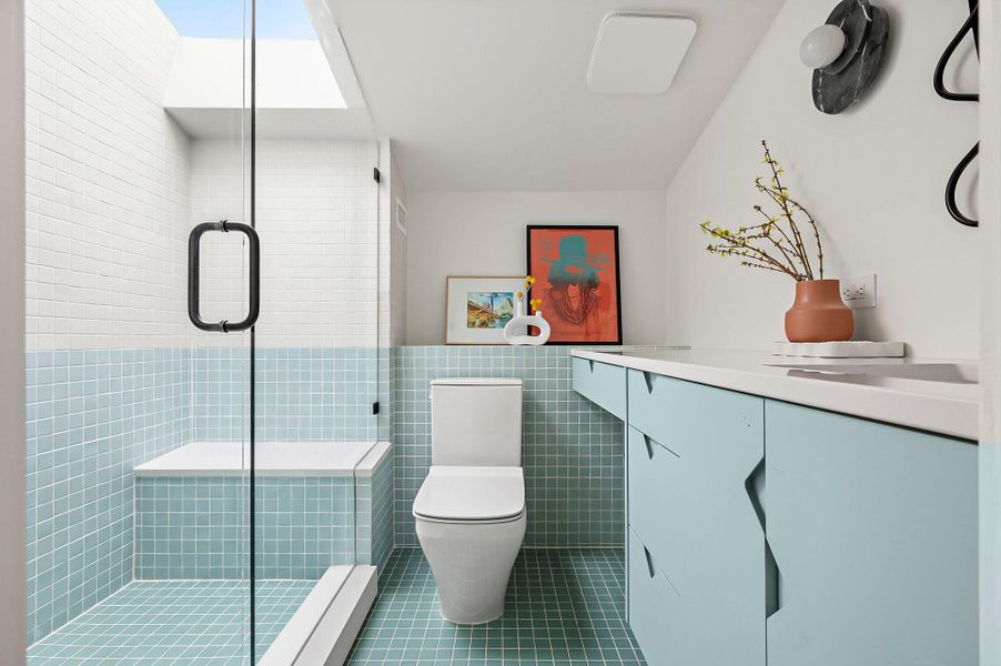 Bathroom featuring toilet, tile patterned flooring, tile walls, and a shower stall Bathroom featuring toilet, tile patterned flooring, tile walls, and a shower stall