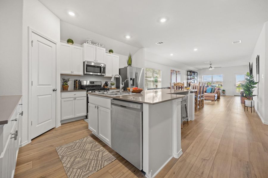 An open-concept living space with a contemporary kitchen flowing into a dining and living area. An open-concept living space with a contemporary kitchen flowing into a dining and living area.