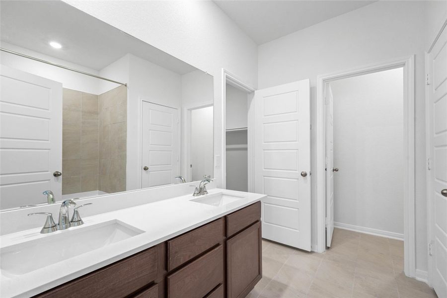 This primary bathroom is definitely move-in ready! Featuring stained cabinets with light countertops, dual vanities, high ceilings, neutral paint, walk-in closet, sleek and modern finishes.