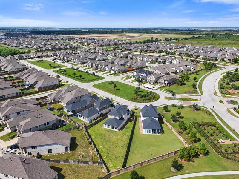 The home is situated in a prime location within the master-planned community of Elyson, close to the main entrance for a seamless commute. The photo shows the open spaces and a glimpse of the neighborhood's walking trails.