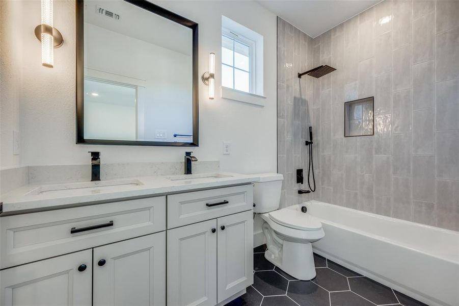 Full bathroom featuring vanity, toilet, tiled shower / bath, and tile patterned flooring