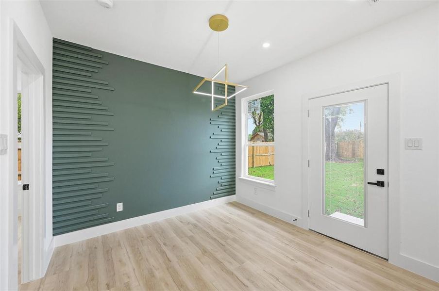 Unfurnished dining area with wainscotting and view of backyard Unfurnished dining area with wainscotting and view of backyard