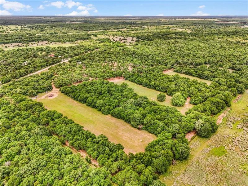 Expansive land parcel featuring dense tree coverage and multiple clearings