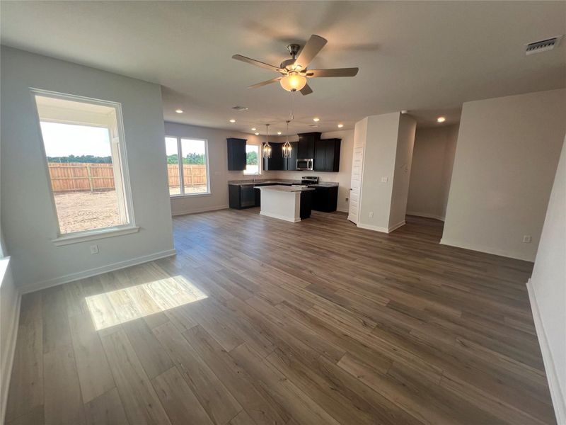An open-concept layout unites living and kitchen spaces with seamless wood-look flooring.