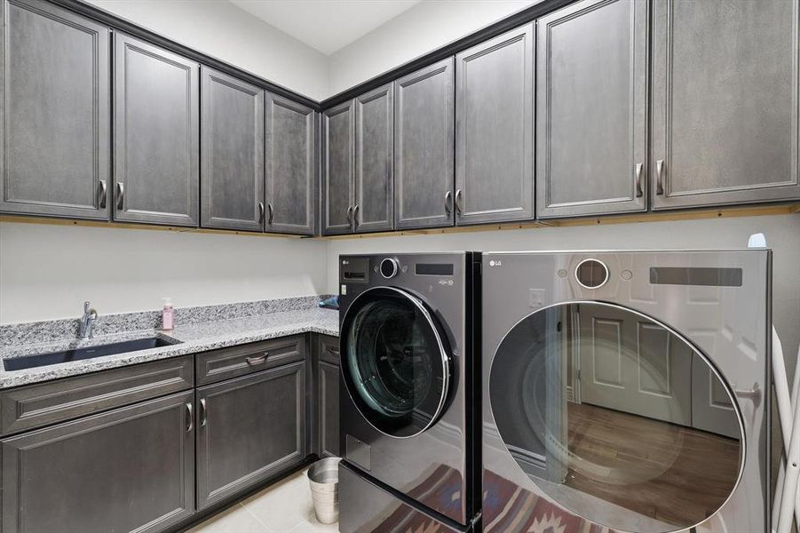 Well-appointed Laundry with Additional Cabinetry, Big Sink, and plenty of Space for Full Size Washer and Dryer.