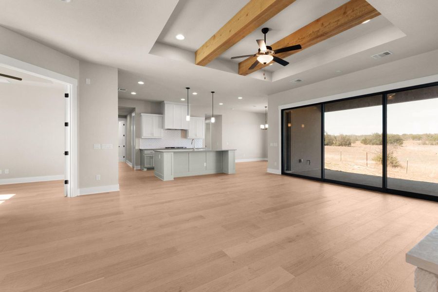 Unfurnished living room with beam ceiling, ceiling fan, a raised ceiling, recessed lighting, and light wood-style floors