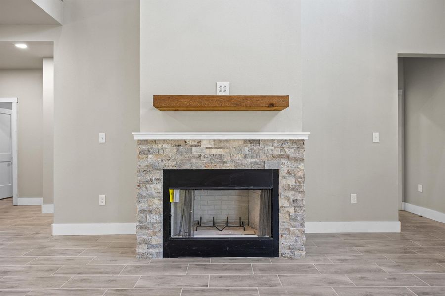 Details with a stone fireplace, baseboards, and wood tiled floor Details with a stone fireplace, baseboards, and wood tiled floor