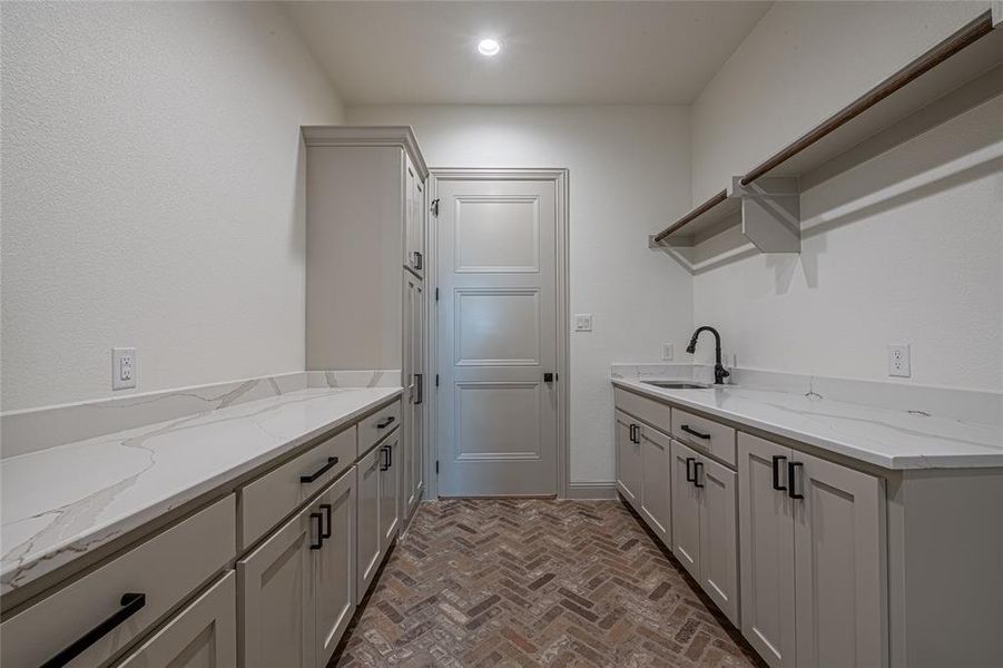 Washroom featuring brick floors and a sink Washroom featuring brick floors and a sink