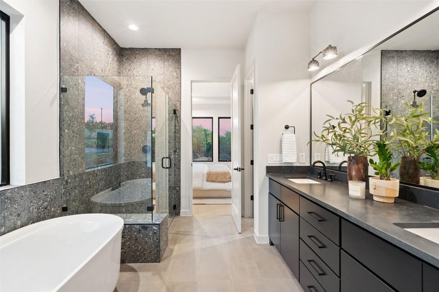 A spacious primary bathroom boasts a freestanding tub, glass-enclosed shower, and a wide double vanity. A spacious primary bathroom boasts a freestanding tub, glass-enclosed shower, and a wide double vanity.