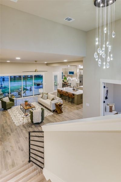 Living area with light wood-like flooring and a chandelier Living area with light wood-like flooring and a chandelier