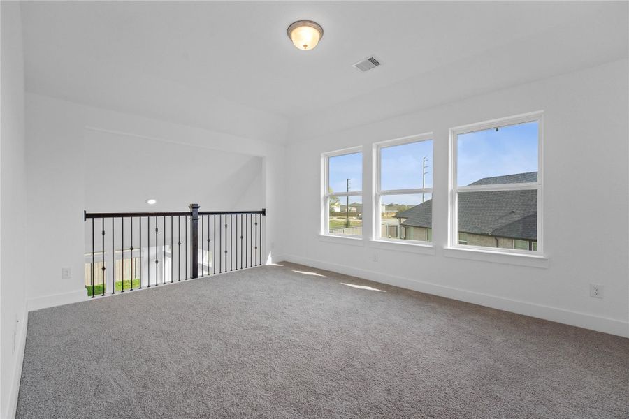 Come upstairs and enjoy a day of leisure in this fabulous game room/media room!!!  This is the perfect hangout spot or adult game room, this space features plush carpet, high ceilings, custom paint and large windows!