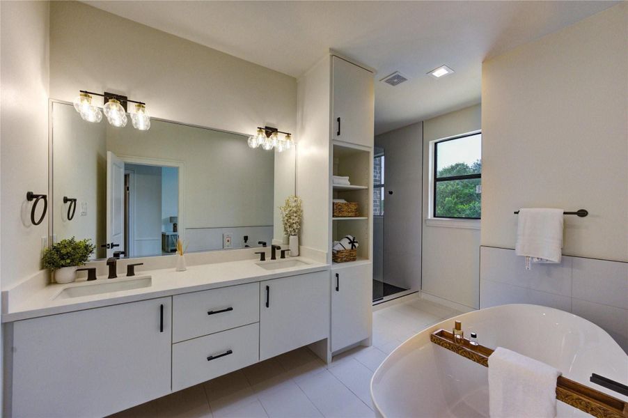 Luxurious primary bathroom featuring dual vanities, modern fixtures, a freestanding soaking tub, and a glass-enclosed shower—designed for comfort and style.