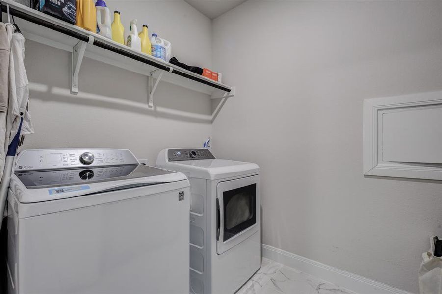 Washroom featuring light marble finish floors and independent washer and dryer