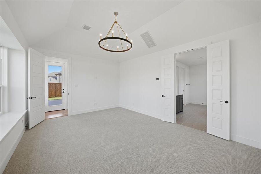 Unfurnished bedroom featuring light colored carpet, a chandelier, and vaulted ceiling Unfurnished bedroom featuring light colored carpet, a chandelier, and vaulted ceiling