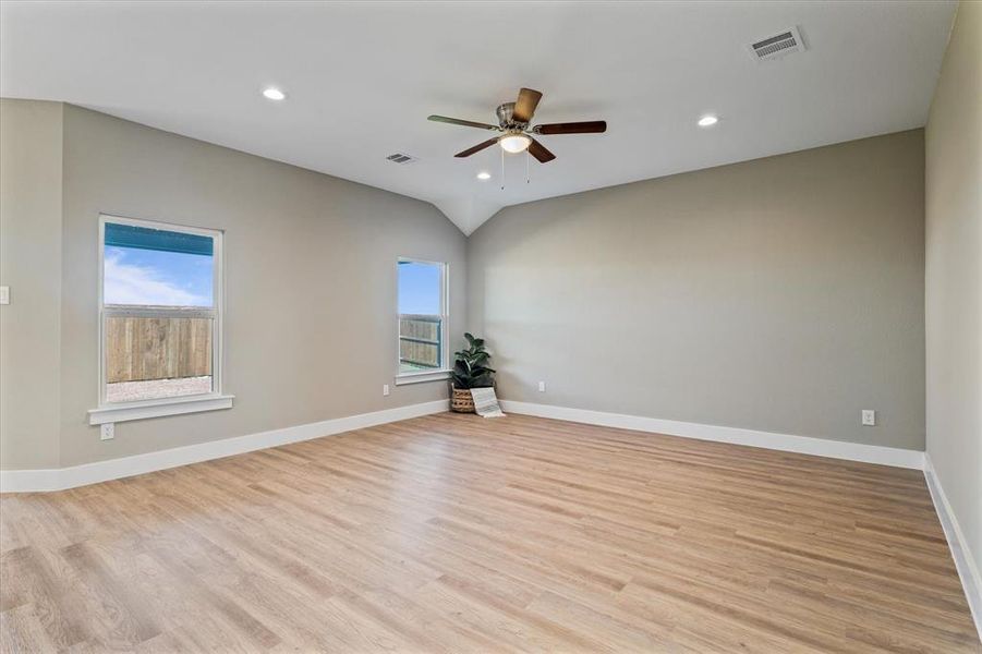 Living room with light wood-type flooring, a wealth of natural light, and ceiling fan