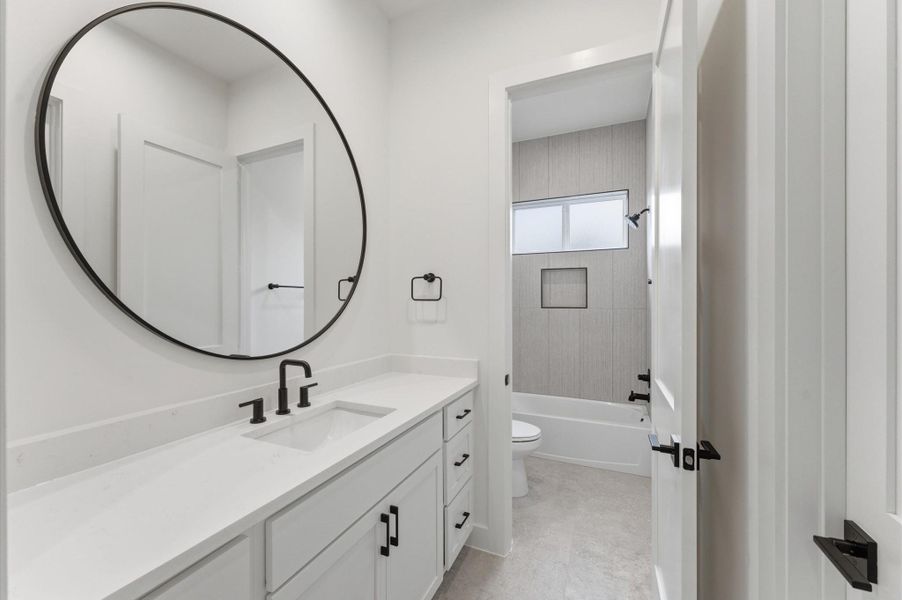 Secondary bathroom with quartz countertops and privacy door to tub/shower combo.