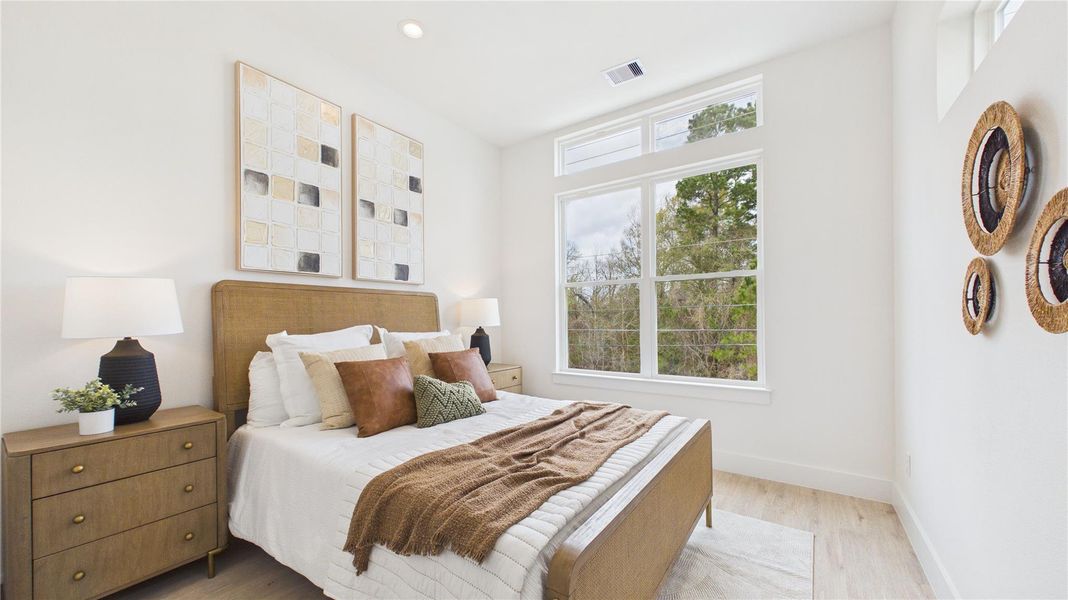The first of two secondary bedrooms; each suite offers no carpet, high ceilings, and a closet at the entryway of the resting quarters!
