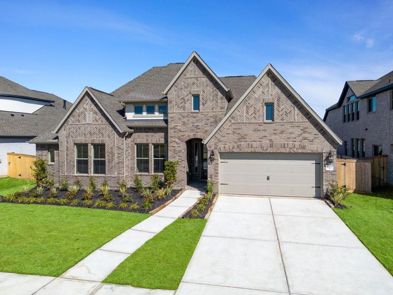 Front exterior of a new home in Valencia 70', Manvel, TX, highlighting curb appeal (Image 21).