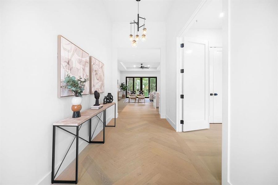 Step through the entrance to discover a haven of warmth, featuring gorgeous wood flooring, a fresh neutral color palette, and contemporary lighting that bathes the open-concept floor plan in an inviting glow