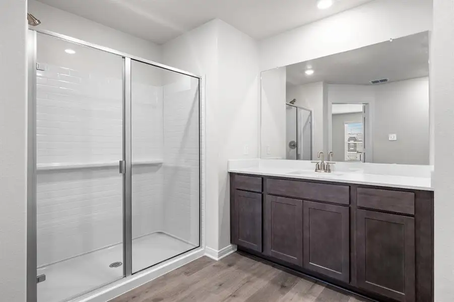Full bath featuring vanity, light wood-style floors, a shower stall, and recessed lighting