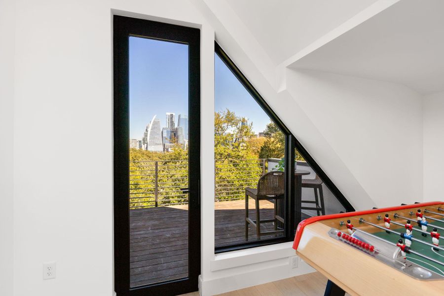 Bedroom featuring wood finished floors, a skyline view, and multiple windows Bedroom featuring wood finished floors, a skyline view, and multiple windows