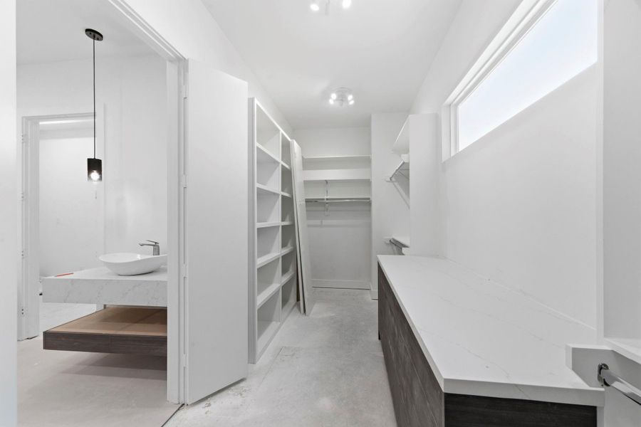 This photo showcases the second walk-in closet, situated within the primary bathroom. It features a complete dressing vanity. This photo showcases the second walk-in closet, situated within the primary bathroom. It features a complete dressing vanity.
