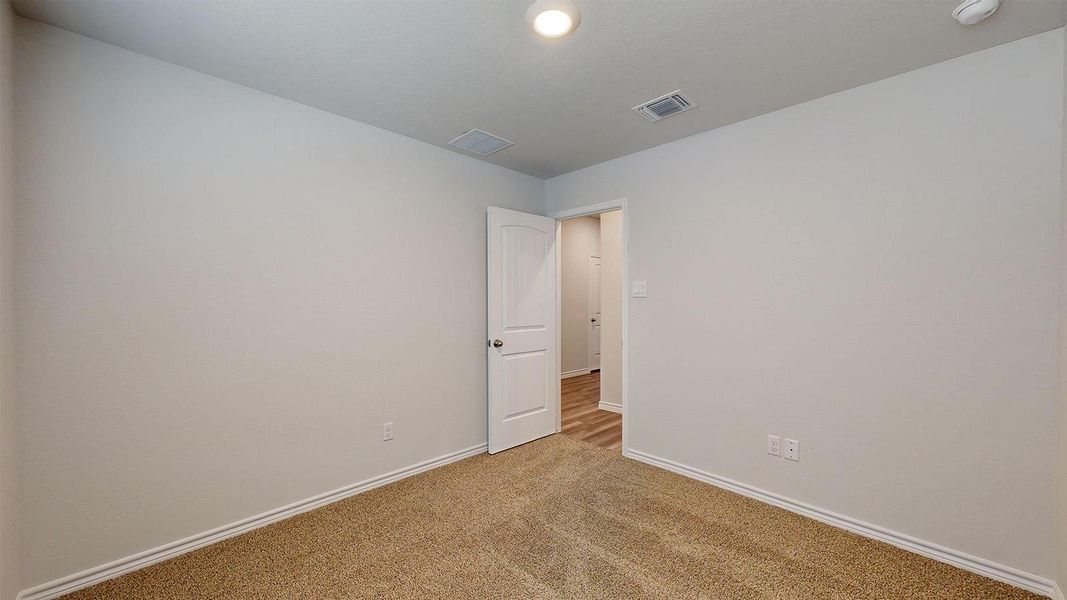 Carpeted spare room featuring baseboards Carpeted spare room featuring baseboards