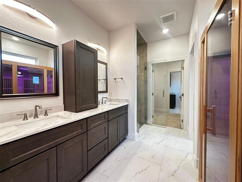 Full bathroom featuring a shower stall, a sink, visible vents, and double vanity