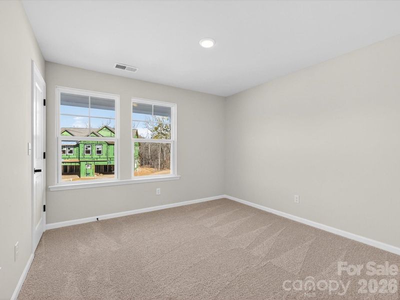 Secondary bedroom features two large windows and walk-in closet