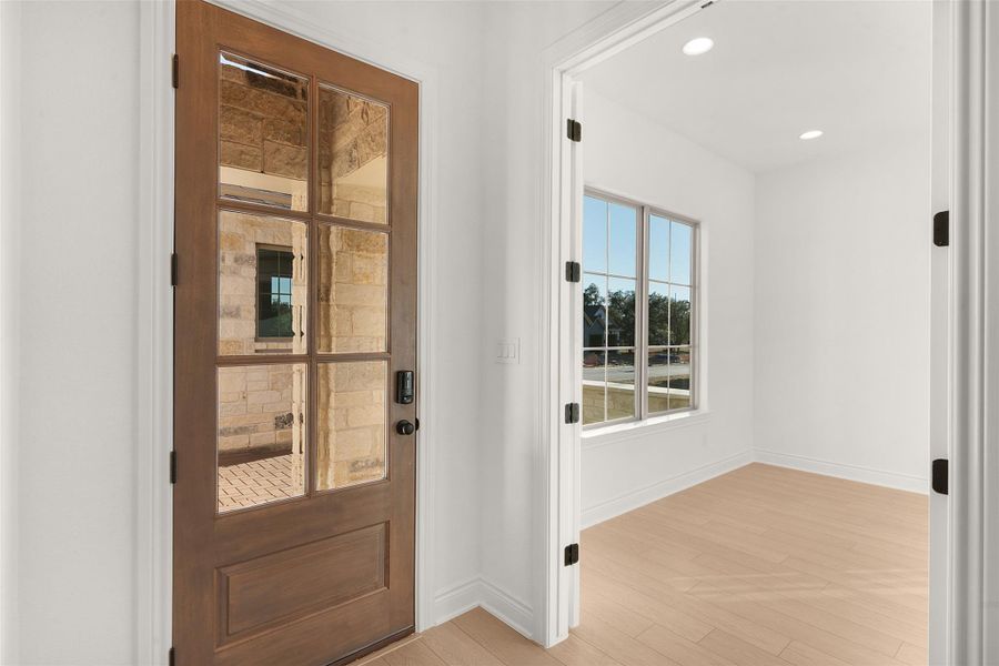 Doorway with wood finished floors and recessed lighting