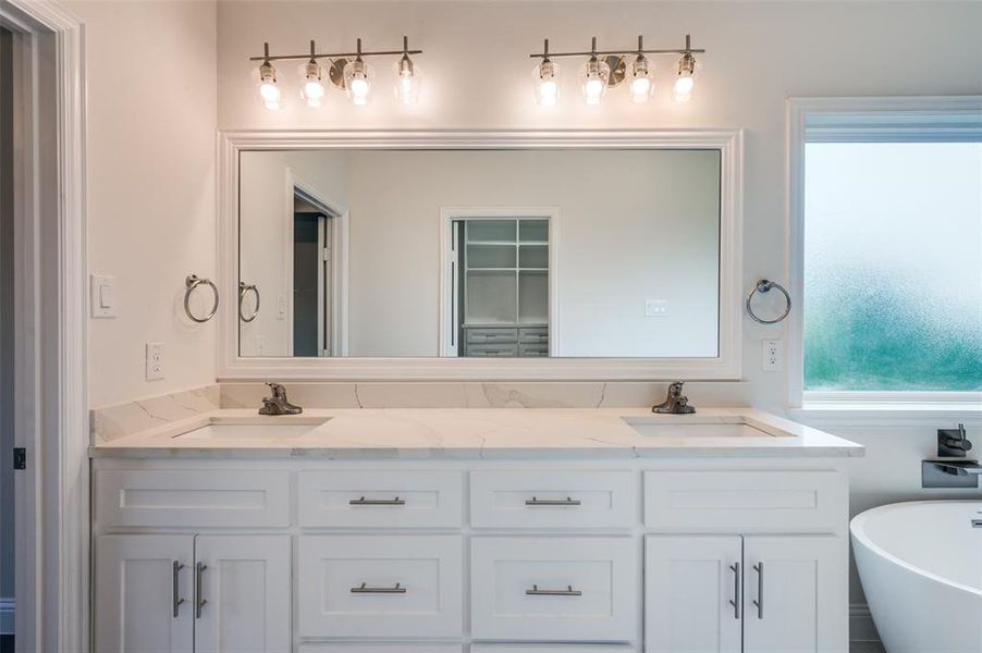 Bathroom featuring double vanity and a bathtub